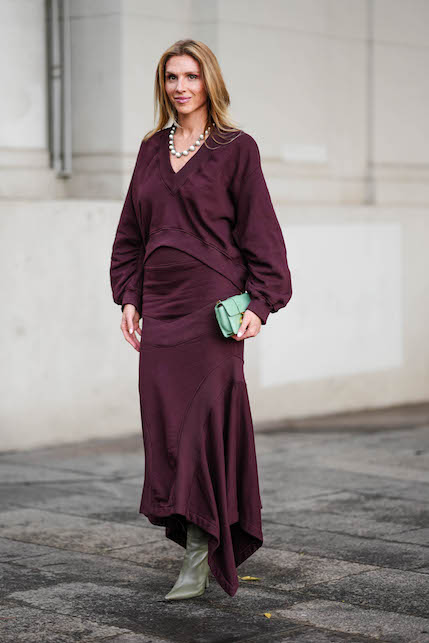 donna con completo bordeaux e pullover a V