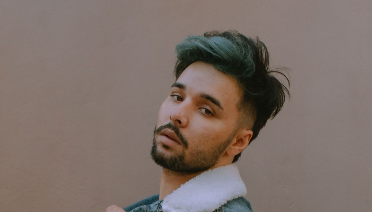 ragazzo moro con la barca e capelli neri e verde menta