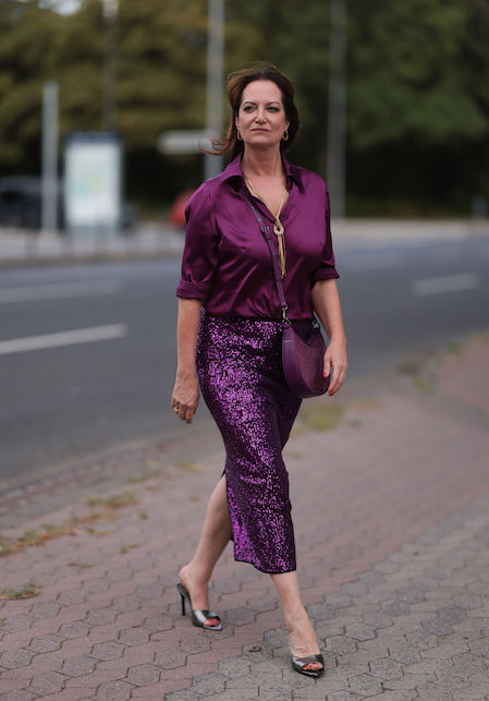 donna con gonna in paillettes e camicia viola