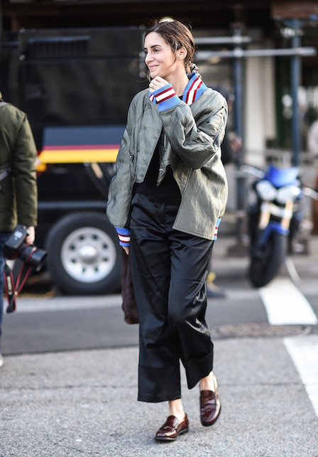 Ragazza con bomber verde, pantaloni neri e mocassini