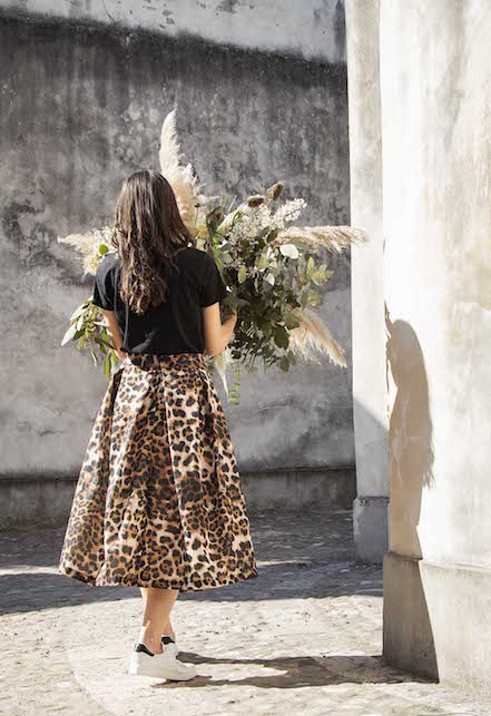 ragazza con t-shirt nera e gonna midi leopardata
