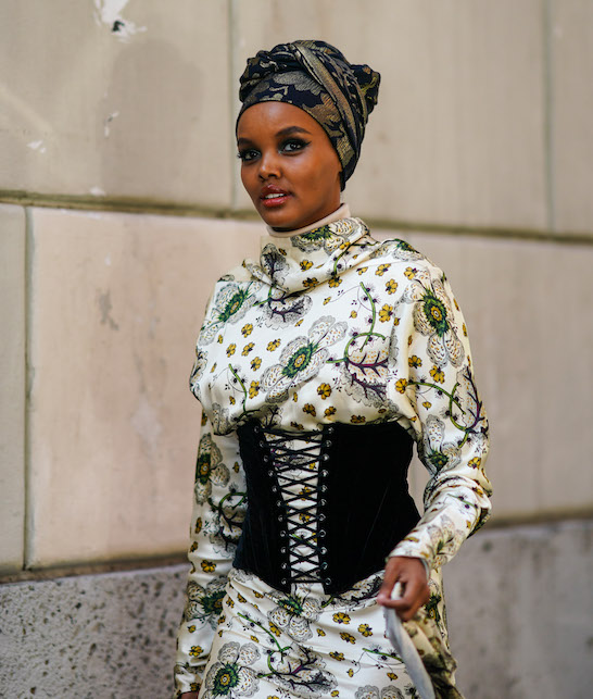 Modella con turbante nero in seta, abito bianco e corpetto nero