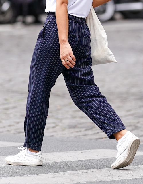 ragazza con pantaloni a righe e sneakers bianche