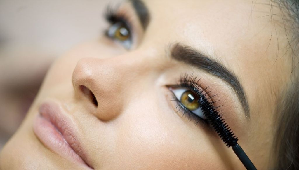 Primo piano ragazza occhi verdi trucco applicazione mascara