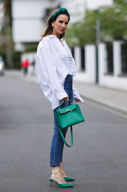 Ragazza con camicia bianca, jeans, borsa e décolleté gioiello verdi
