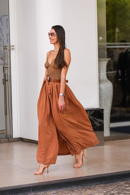 Modella con body marrone e gonna rosso mattone