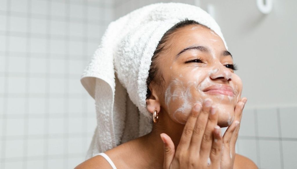 Ragazza nera turbante capelli si lava il viso sapone schiuma