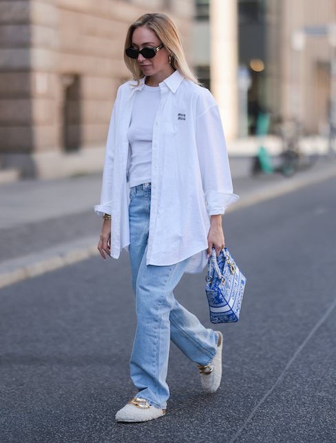 Ragazza con camicia aperta, canotta, jeans e sneakers