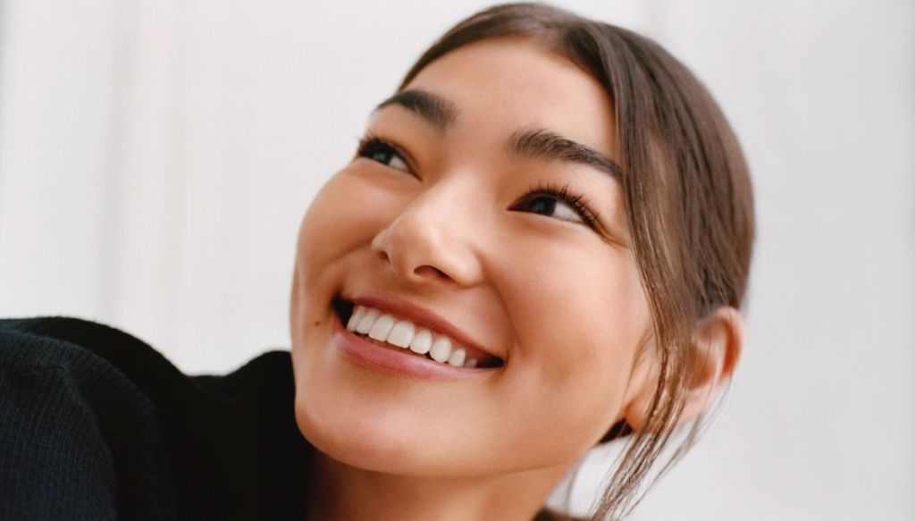 ragazza asiatica capelli castani sorridente trucco naturale