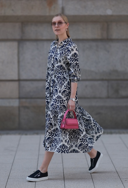 donna con abito lungo a fiori blu e sneakers