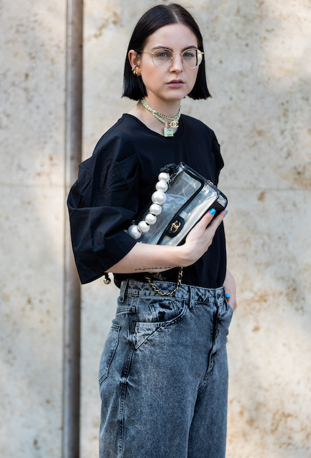 ragazza con maglia nera e borsa cn manico di perle