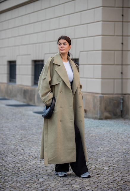 ragazza con trench, maglia bianca e pantaloni neri