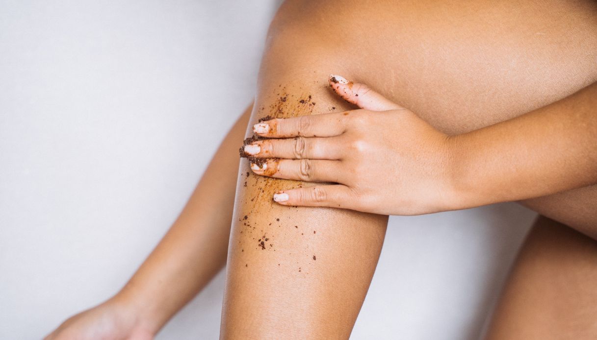 donna nera passa scrub sulle gambe
