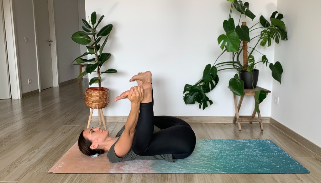 posizione yoga happy baby