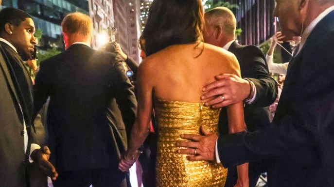 Meghan Markle rivestita d’oro. Ma la mano finisce dove non dovrebbe