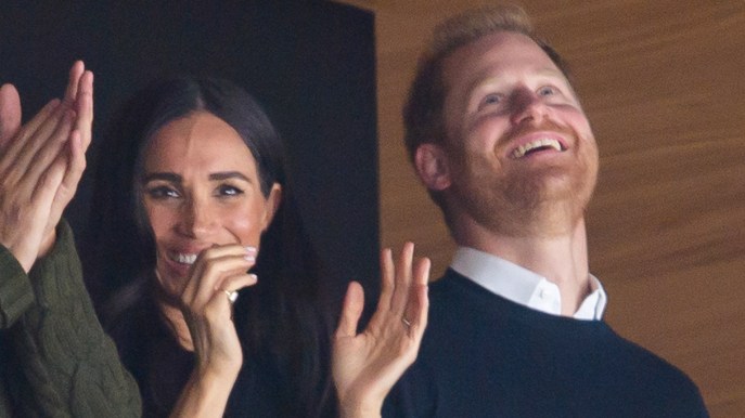 Harry e Meghan Markle allo stadio: lui imita Elisabetta II, lei ha un look da 143.455 euro
