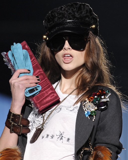 ragazza con spille sulla giacca, cappello e occhiali