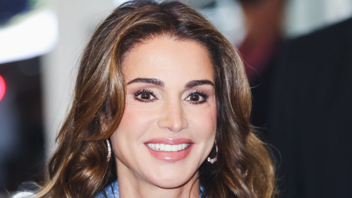 Rania di Giordania abbagliante in gonna plissettata e camicia rosso fuoco