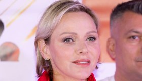 Charlene di Monaco, madrina con la pistola in mano e i pantaloni di Louis Vuitton